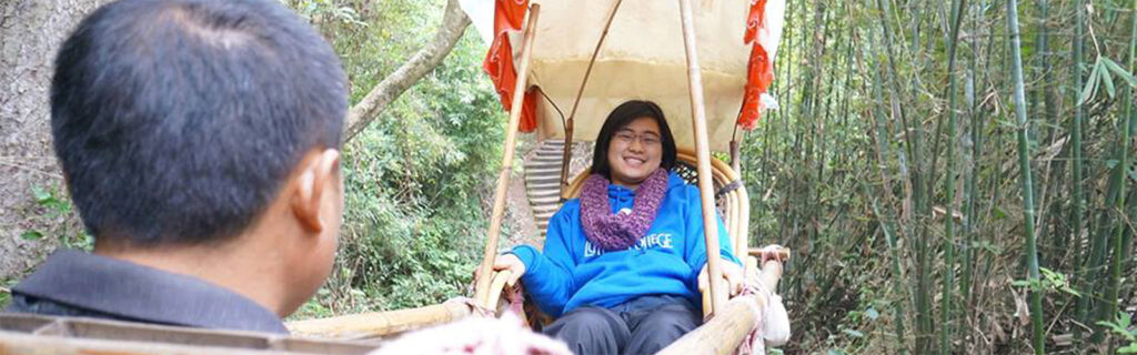 Alahna Keil on a sedan chair being carried