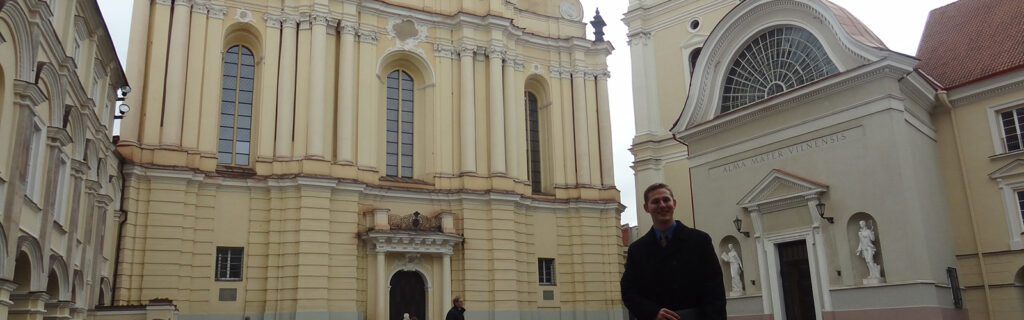 Travis Gunn in front of historical buildings in Lithuania