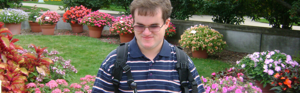 Andrey sits in front of flower garden