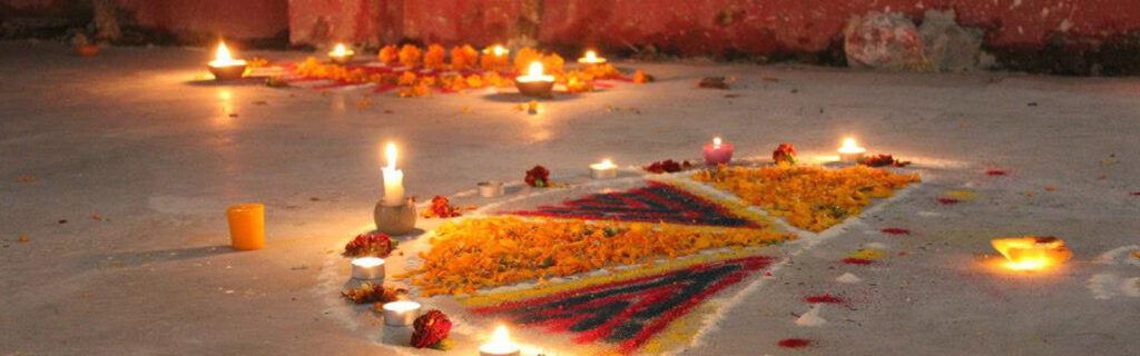 In India, a beautiful scene of colors and candles is assembled on the ground.