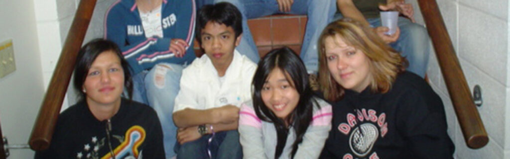 Marlon and several of his classmates display serious faces as they are seated on the stairs of their high school.