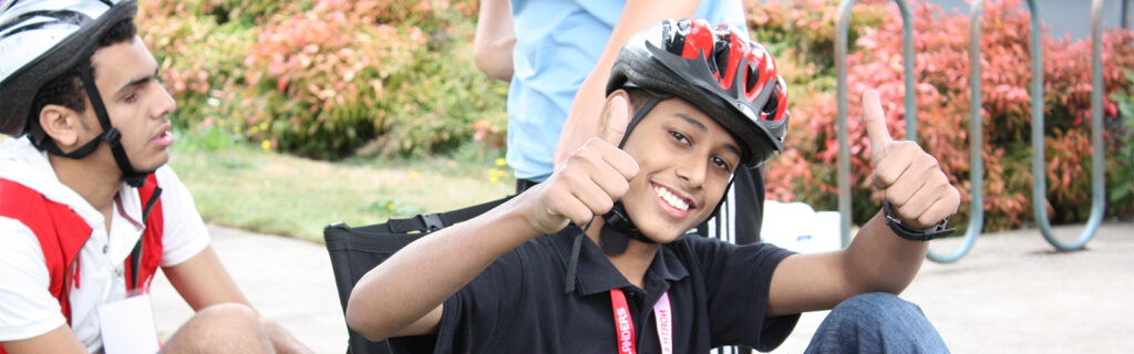 Muhammad gives two thumbs up as he gets set up on a recumbent bicycle.