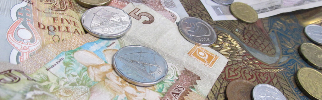 An assortment of foreign currencies are scattered on a table.