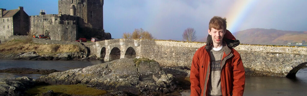 Rainbow and castle behind a young man