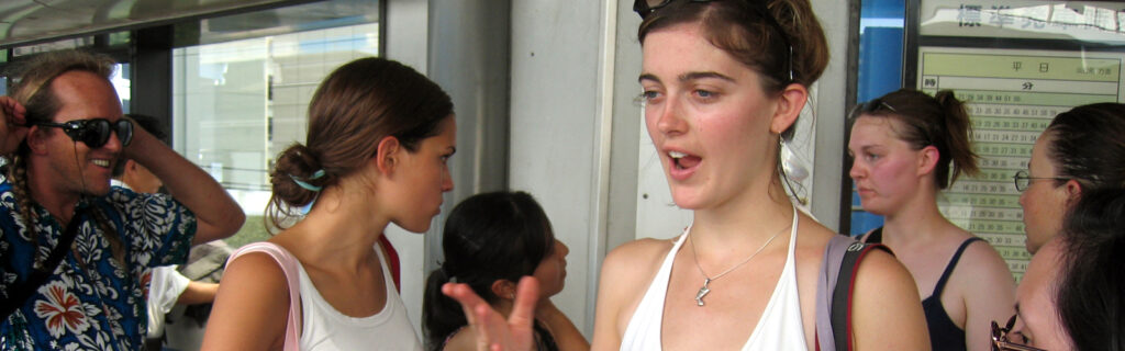 A young American woman in a crowded market in Japan.