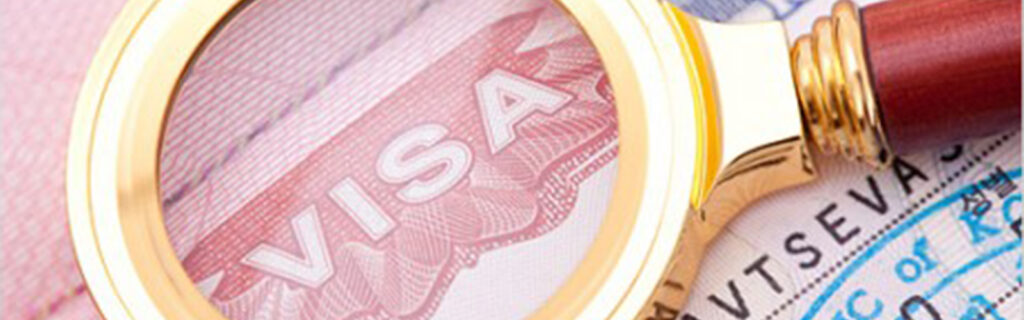 A magnifying glass is held to a document labeled "visa."