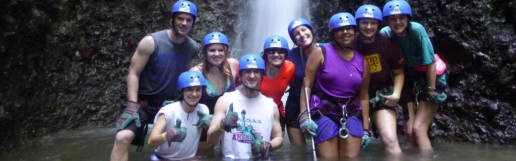 Juanita Lillie with other program participants under waterfalls in rockclimbing gear