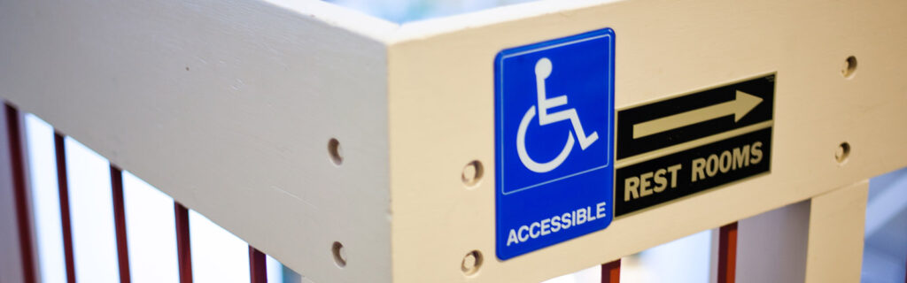 Wheelchair access sign with restroom arrow