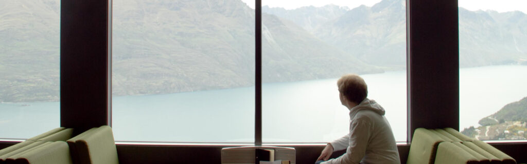 Kevin Cosgrove sits by a window overlooking a body of water