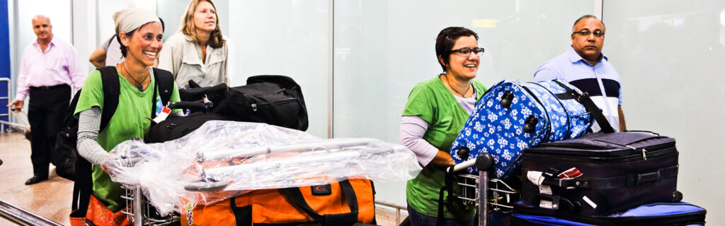 Travelers push carts full of luggage through an airport terminal