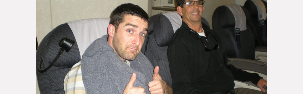 Exchange participant gives thumbs up from his airplane seat at the start of his journey