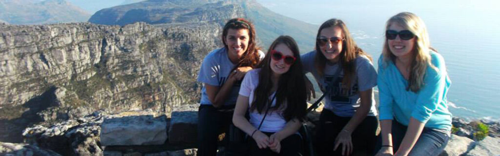 Shannon in front of mountain vista with three other young women