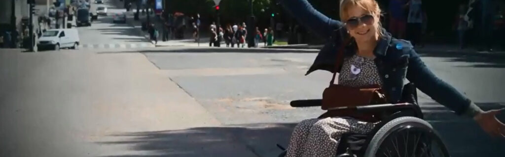 Screenshot of Yulia in wheelchair raising her arms outside