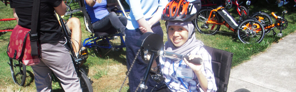 Lintang sits in an adaptive bicycle