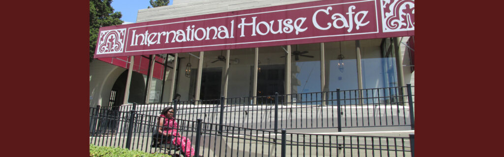 International student rides down a ramp using her wheelchair in front of the "International House Cafe".