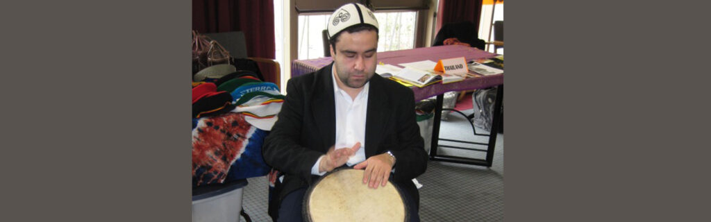 Mohammed playing the drums wearing a traditional hat.