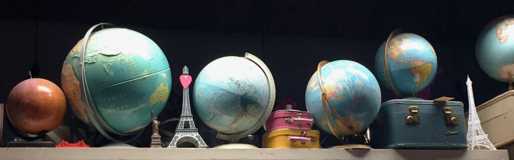 Spherical globes and minature suitcases and Effiel Tower in a line