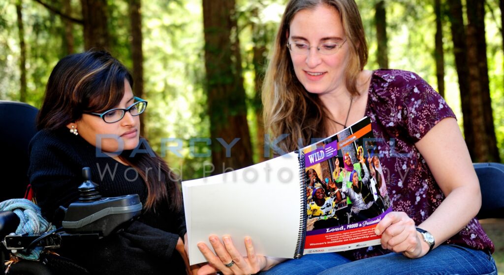 Two women look at the WILD Facilitator's manual