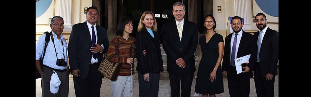 RightsNow! team members, members of El Colectivo, members of the Disability Affairs Commission stand and smile for a photo in the entrance to the Guatemalan Congress