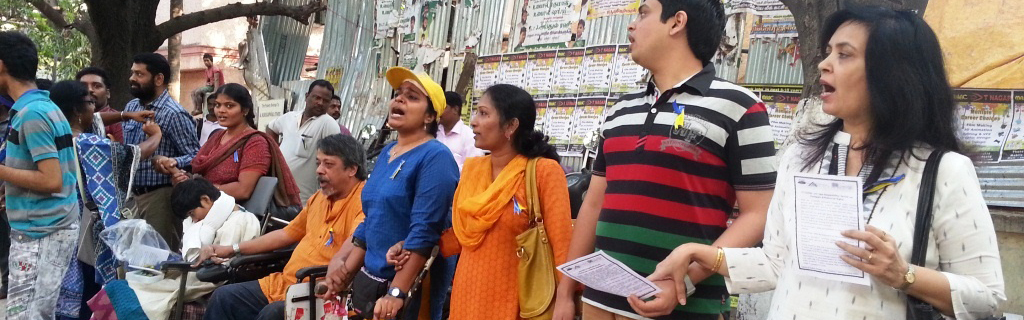 Men and women with disabilities in India gather outdoors for disability rights event