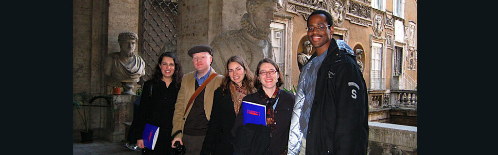 Joseph standing with 4 others in front of Roman statues.