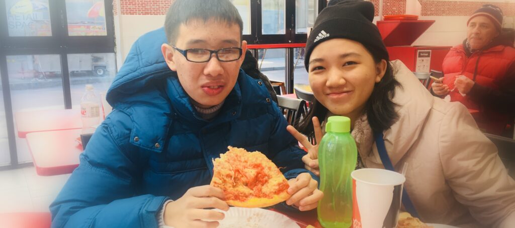 Two students eating pizza in a restaurant in NYC