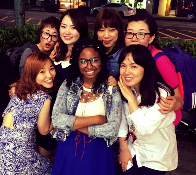 Michelle Morris (center) surrounded by six young Korean women who hug Michelle.