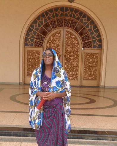 Justice wearing head scarf in front of ornate mosque door