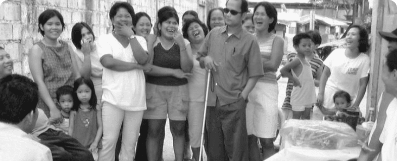 A group of Vietnamese people gather around a blind man