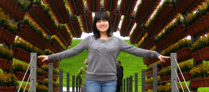 Asian-American youth stands under potted plants in Germany